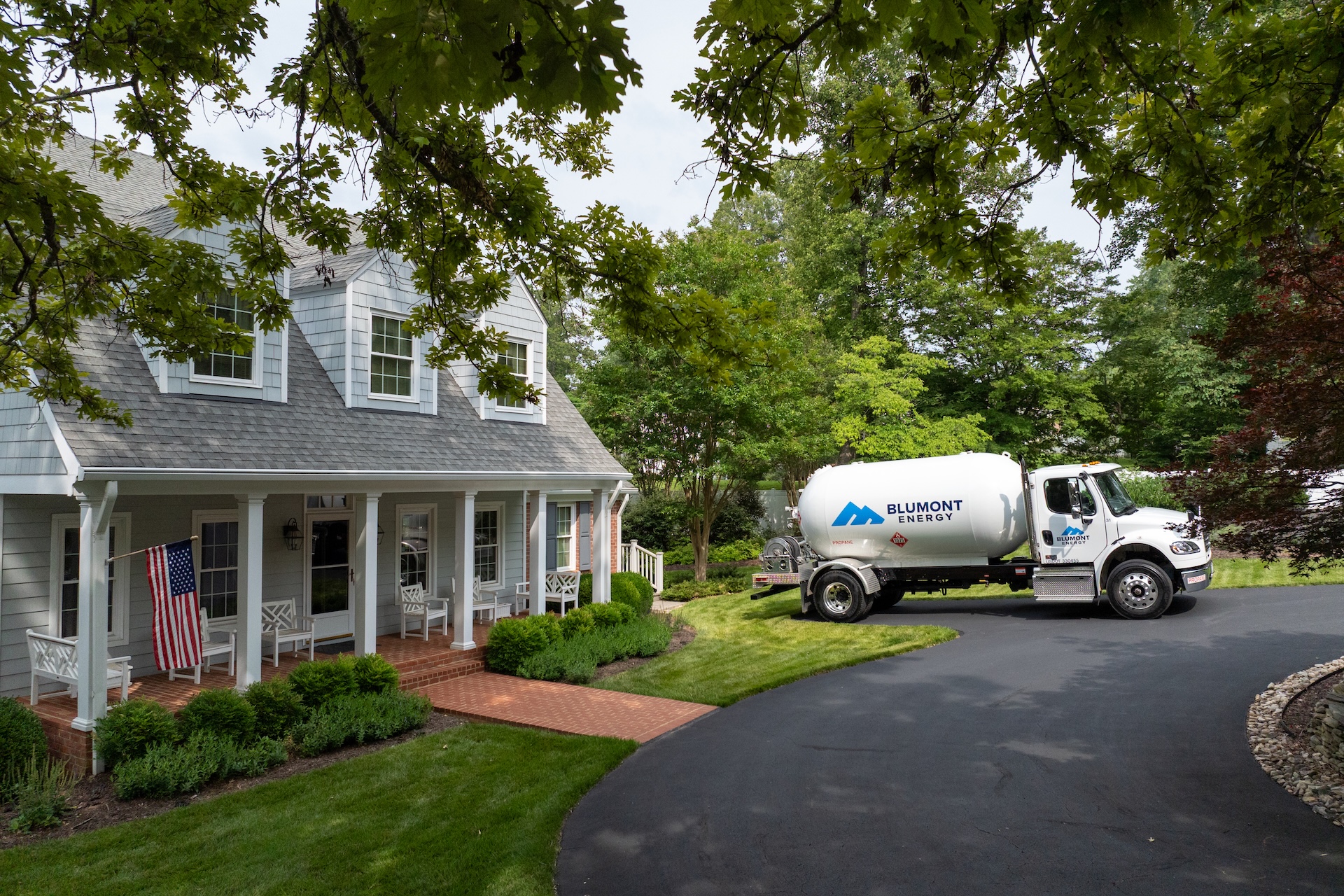 Blumont Energy propane truck is parked outside a customer's home, preparing for delivery. Custom photography by Estland.