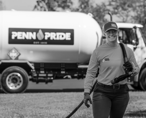 Alex Vespico, VP of Penn Pride, carrying a propane hose away from a Penn Pride truck.